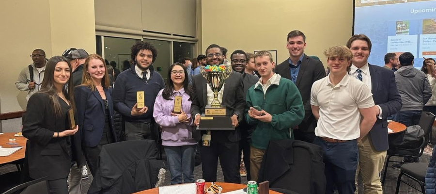 Drexel construction managment students gather and pose with prize winning trophy